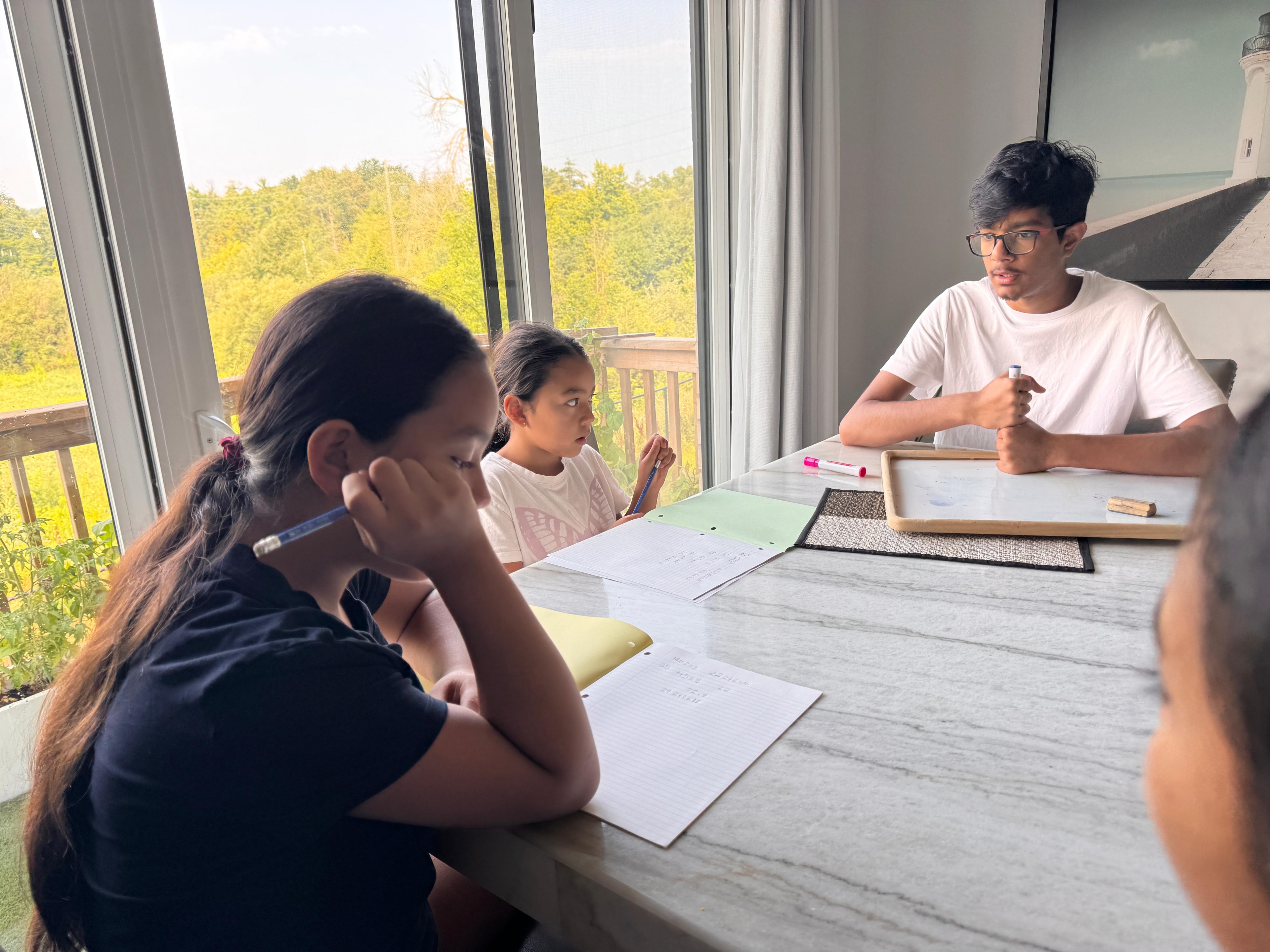 Instructor teaching students at the table during the August 2026 camp