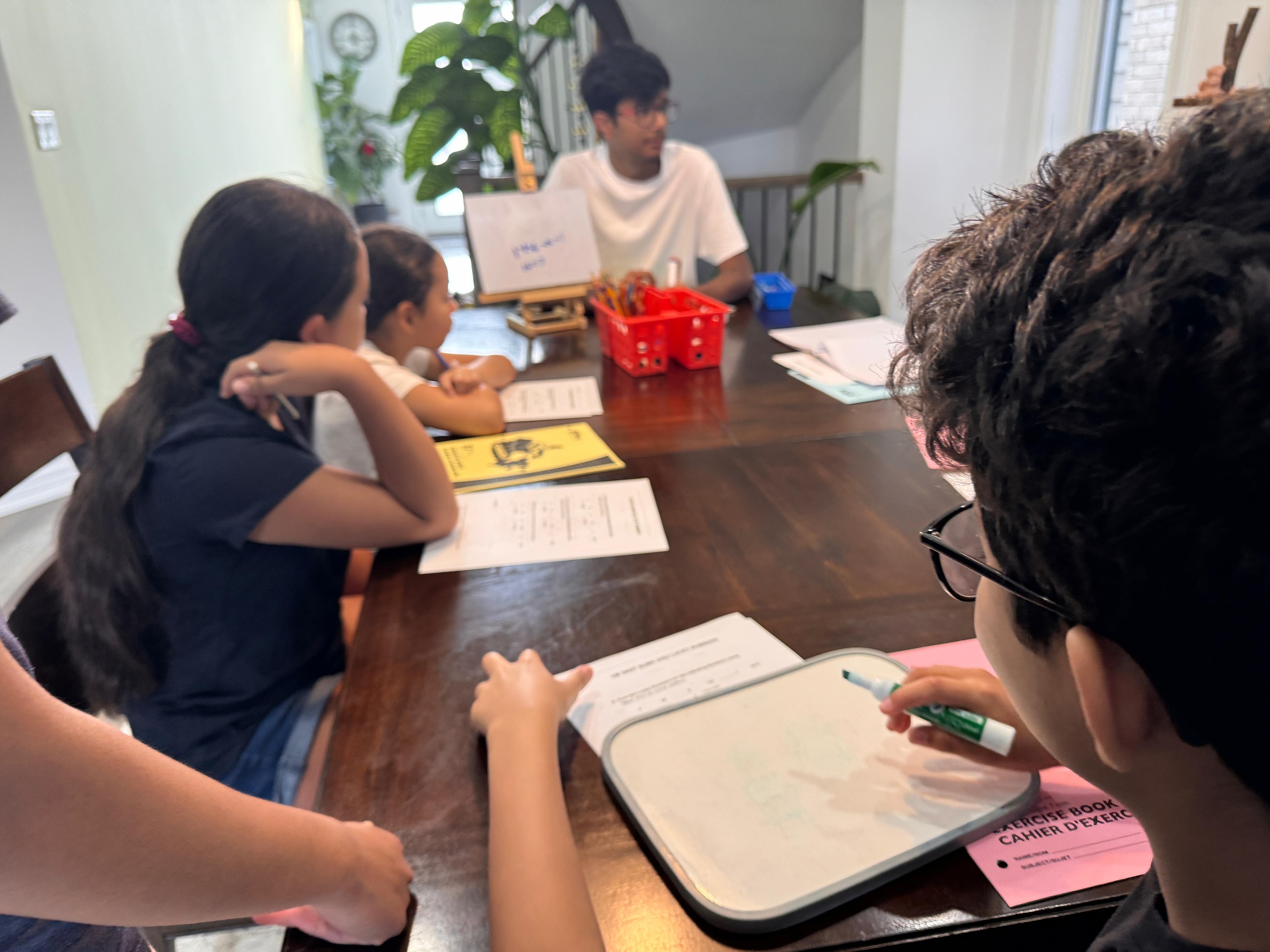 Instructor at the whiteboard with students during the August 2026 camp