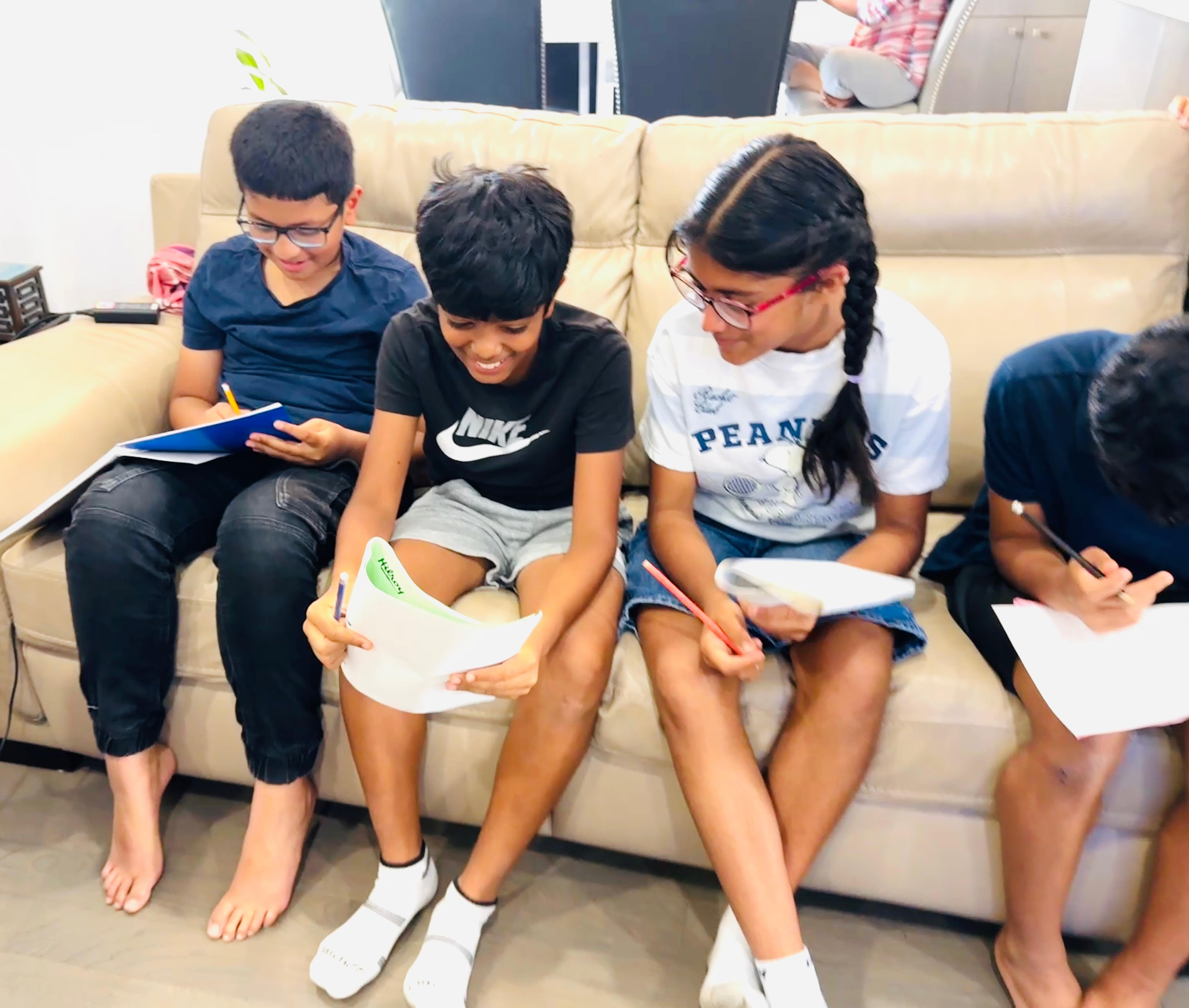 Students working through math problems together on the sofa